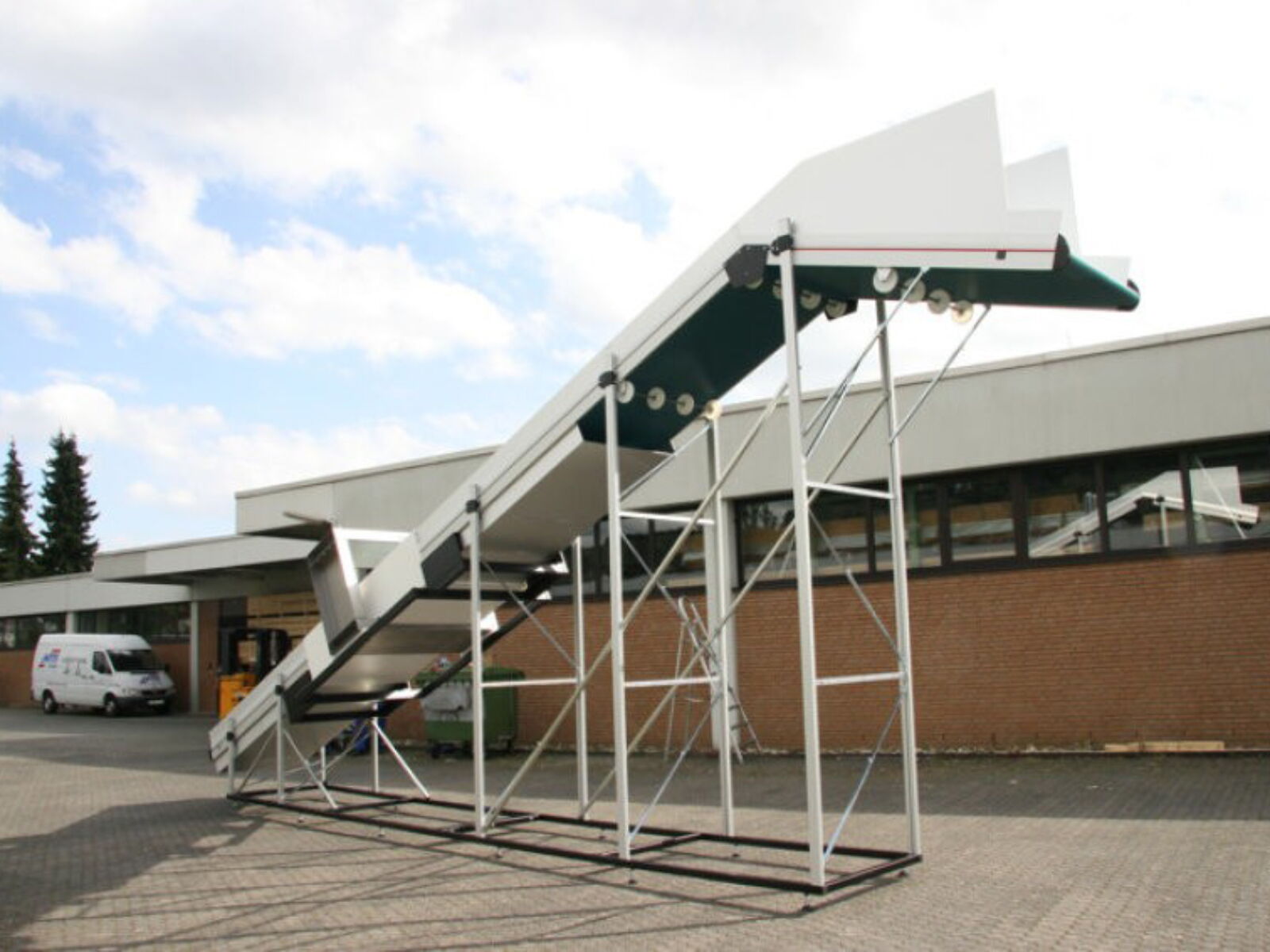 Positively angled, high infeed conveyor belt with metal detector for a safe conveying of plastic parts in granulator